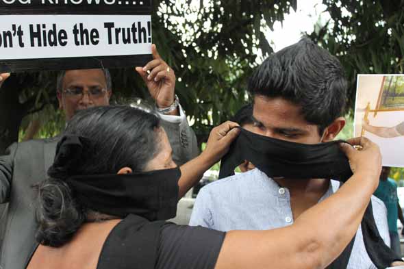 අම්මා(සංධ්යා එක්ණැලිගොඩ) සිය පුතුට විරෝධතා මුඛවාඩම පළදවන අයුරැ