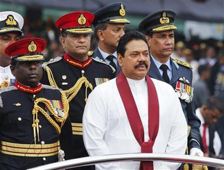 Sri Lanka's President Mahinda Rajapaksa inspects troops from an army vehicle during a war victory ceremony in Colombo